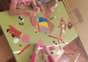 Dziewczynki zwijają papier w harmonijkę
